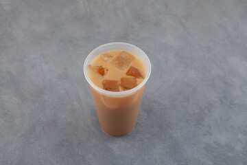 New Orleans-style coffee or Iced chicory latte. Chicory ersatz coffee with ice cubes in disposable plastic cup. Refreshing cold drink. Takeaway street food beverage