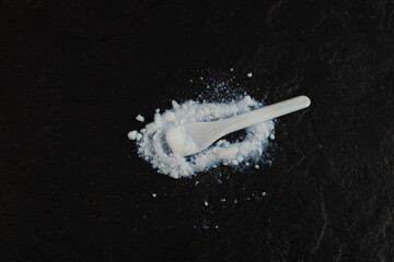 E551 Food additive. Powder of Colloidal silicon dioxide on black stone surface. Enterosorbent powder. Anti-caking agent. Highly dispersed pyrogenic SiO2 used in medicine, food and cosmetics