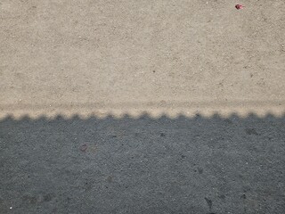 Surface detail of weathered pavement joining area between asphalt and concrete, captured with...