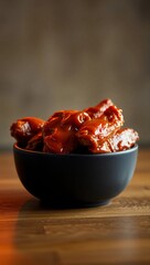 buffalo wings glossy sauce black bowl 45-degree angle moody lighting chicken wings spicy food gourmet ceramic
