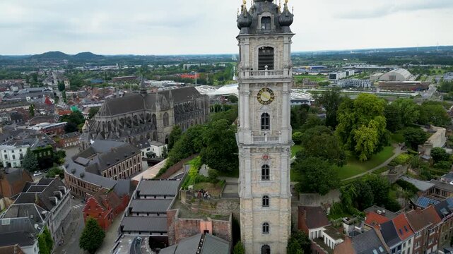 Aerial view of Belfry of Mons, a towering structure, stands amidst the city's architectural tapestry, contrasting with the green spaces, Mons, Belgium.