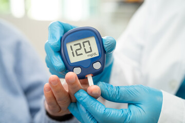 Doctor check diabetes from finger blood sugar level with finger lancet.