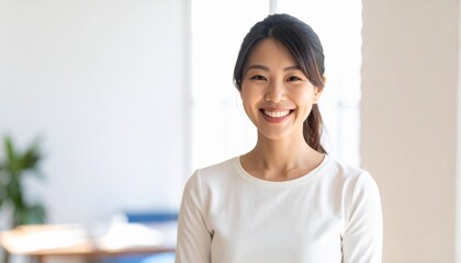 明るい室内で笑顔を見せる若い日本人女性のポートレート
