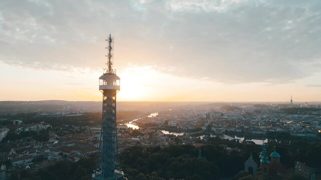 Witness a breathtaking sunrise over Prague from the Petrin Lookout Tower. The city awakens with stunning views of rivers and lush landscapes, creating a serene atmosphere.