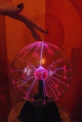 Female fingers touching plasma ball close up