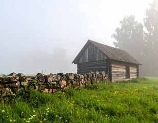 A solitary wall from a ruined hunting lodge, surrounded by mist and grass, creating a desolate, haunting outdoor scene.