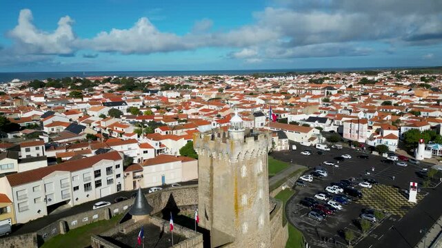 Aerial view of Arundel Tower and the surrounding city with orange rooftops contrasting against the blues of the sky and sea, Les Sables-d'Olonne, Pays de la Loire, France.