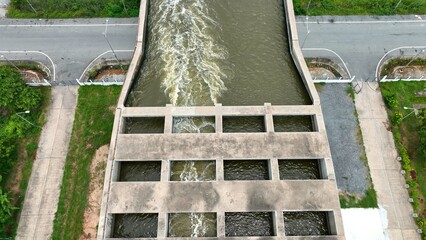 A pumping station moves water to the transfer bridge, directing flow efficiently toward the sea to manage drainage and prevent flooding. Thailand. Drone view.
