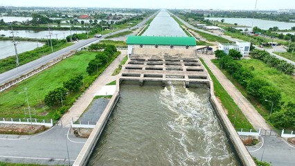 A pumping station channels water into the Transfer Bridge, ensuring smooth flow and effective drainage into the sea as part of a smart water management system. Thailand. Drone view.
