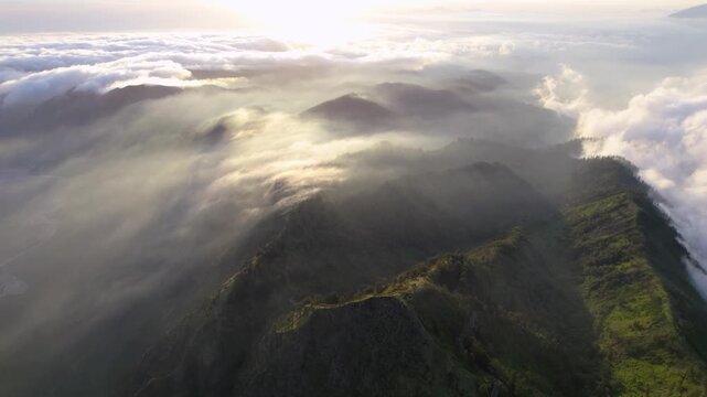 Aerial view of mountain peaks rising through a sea of low-lying clouds, a stunning display of nature's majesty, Bromo Tengger Semeru National Park, East Java, Indonesia.