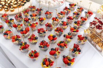 Berry desserts served in clear cups at a festive outdoor gathering in the afternoon