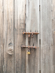 Rusty Padlock on Aged Wooden Door.