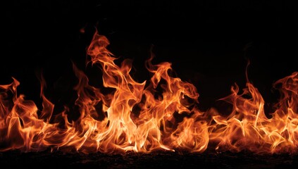 Fototapeta premium Fiery flames against a black backdrop