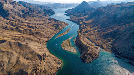 Aerial view of a river winding through a desert canyon landscape, showcasing nature's grandeur. Desert meets water, creating an incredible contrast.