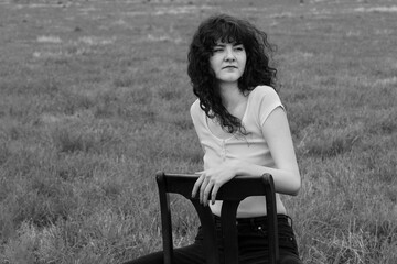 Young woman sitting on chair outdoors