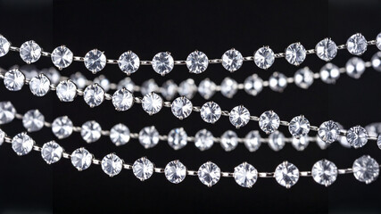 A stunning, close-up shot of sparkling diamond-like jewels arranged in multiple horizontal strands. The black background and selective focus create an elegant and luxurious aesthetic.