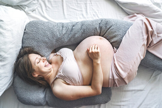 Pregnant mother relaxing on bed enjoying quality time at home
