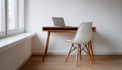 Simple modern workspace with wooden desk, laptop, and chair by a window