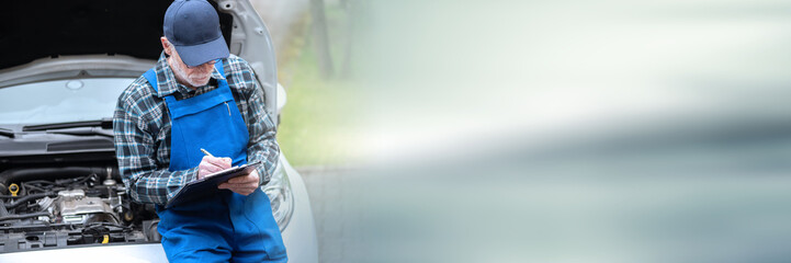 Car mechanic checking a car engine; panoramic banner