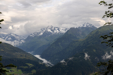 Majestic snow-covered alpine peaks under dramatic cloudy sky. High mountain range in Tyrol