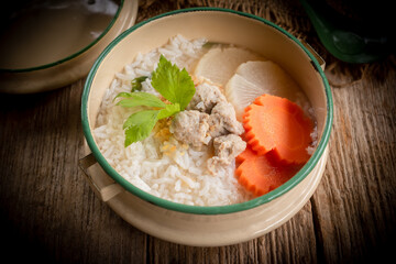 Pork congee  is placed on the dining table. Retro Thai style image.