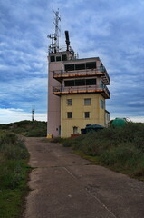 Former Vessel Traffic Service Tower on The Spurn in Yorkshire with dark clouds