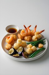 Plate of mixed tempura with shrimp, vegetables and dipping sauce