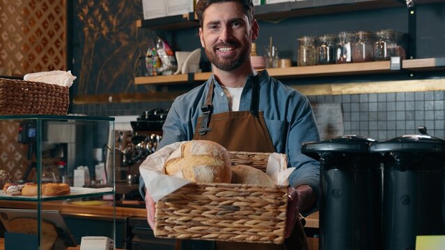 Smiling Caucasian waiter man guy worker showing food basket barista offering to customer fresh bread bakery catering in cafeteria small business cafe restaurant entrepreneur male working coffee shop - Powered by Adobe