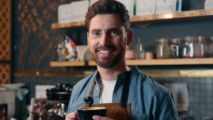Satisfied Caucasian waiter barista man guy holding coffee cup bartender working in cafeteria worker...