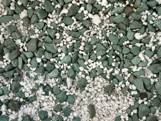 Close up green and white pebbles on landscape garden or park. Pebble stone is a good choice for...