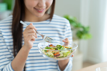 サラダを食べる若い女性