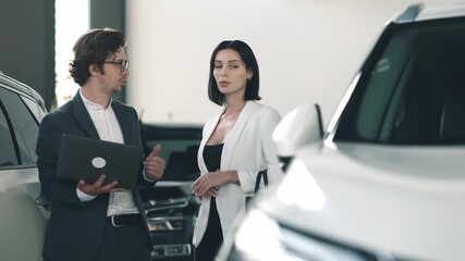 Businessman and woman discussing car options at dealership, showcasing modern vehicles and engaging customer service experience in bright showroom - Powered by Adobe