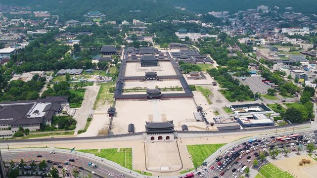 한국의 경복궁을 드론으로 높은 고도에서 전경이 모두 보이도록 우측으로 회전하며 촬영, 맑은 하늘과 여름날, 푸른 잔디