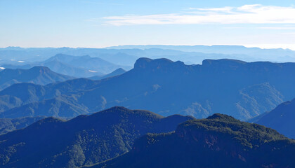 Fototapeta premium Expansive Mountainous Landscape with Lush Green Valleys and a Clear Blue Sky
