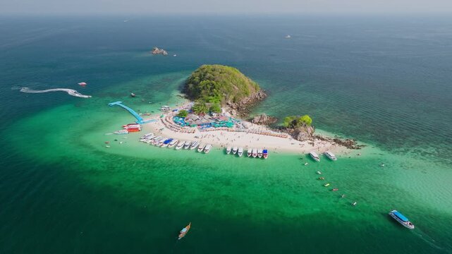 Aerial view of Koh Khai Nok island with boats docked along the shore and people enjoying the beach, Phru Nai, Phang Nga, Thailand.