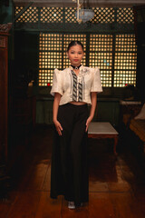 Full-body portrait of Filipina woman in stylish Filipiniana attire standing confidently in a preserved Filipino ancestral home.