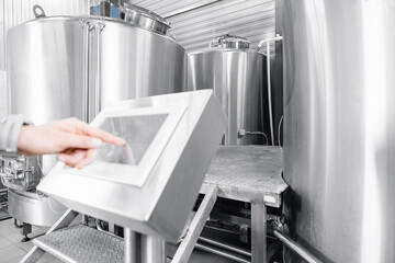 Operator uses computer to check quality and temperature of yeast fermentation in tanker hops and...