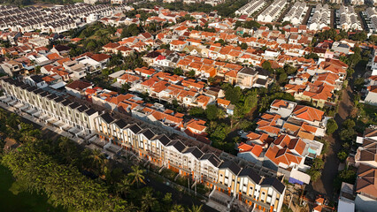 Aerial drone view of densely populated urban neighborhood with narrow streets and compact housing....