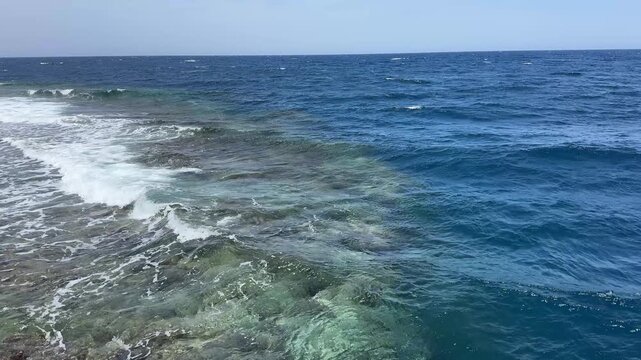 Gentle waves crashing on a shallow coral reef in the red sea