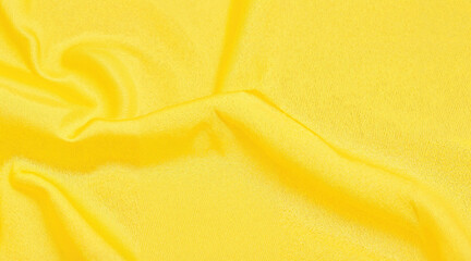 Smooth yellow fabric with soft texture draped on a surface  