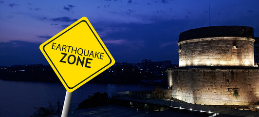 Caution Earthquake Zone Sign on Cracked Rock Background