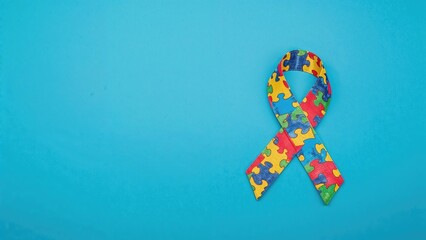 Creative Illustration for Autism Awareness Month or Day. Color Puzzle Symbolizing Autism Spectrum on Blue Background. Top Down View with Copy Space.