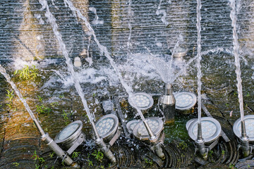 Water splashes from a fountain close-up. Stainless steel water fountain. Fountain jets in public...