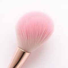 Close up of a pink makeup brush with a gold handle on a white background in a studio setting shot up close