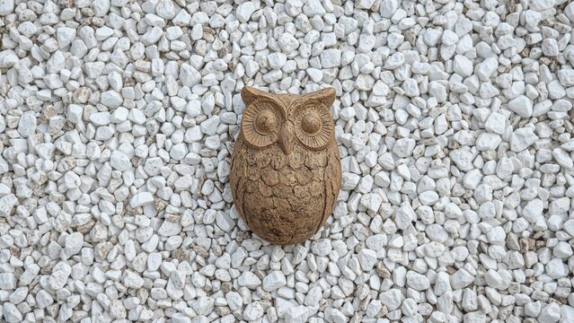 Sculpted owl set against a white stone backdrop