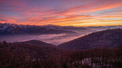 Obraz premium Expansive sunset panorama across fog-covered peaks