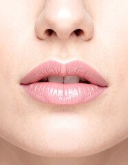 Fototapeta premium A close-up of a woman's lips adorned with vibrant pink lipstick, showcasing a glossy finish and a subtle sheen, highlighting their natural shape and texture.