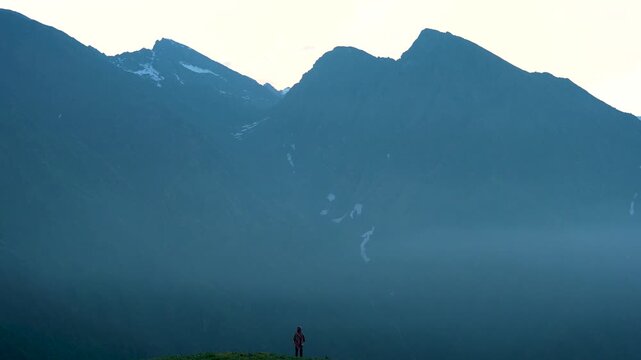 4k footage ; one man taking pictures of the beautiful of the rising sun on high hill, and a group of white fog moving along the lower tree line. amazing of Mea Tang, Chiang Mai, Thailand. 
