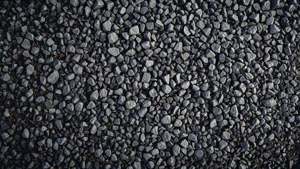 Construction-grade gray granite gravel crushed rock, macadam scree texture ground layer. Aggregated loose rock fragments for building.