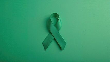 Symbolic green ribbon displayed on a green background for mental well-being day.